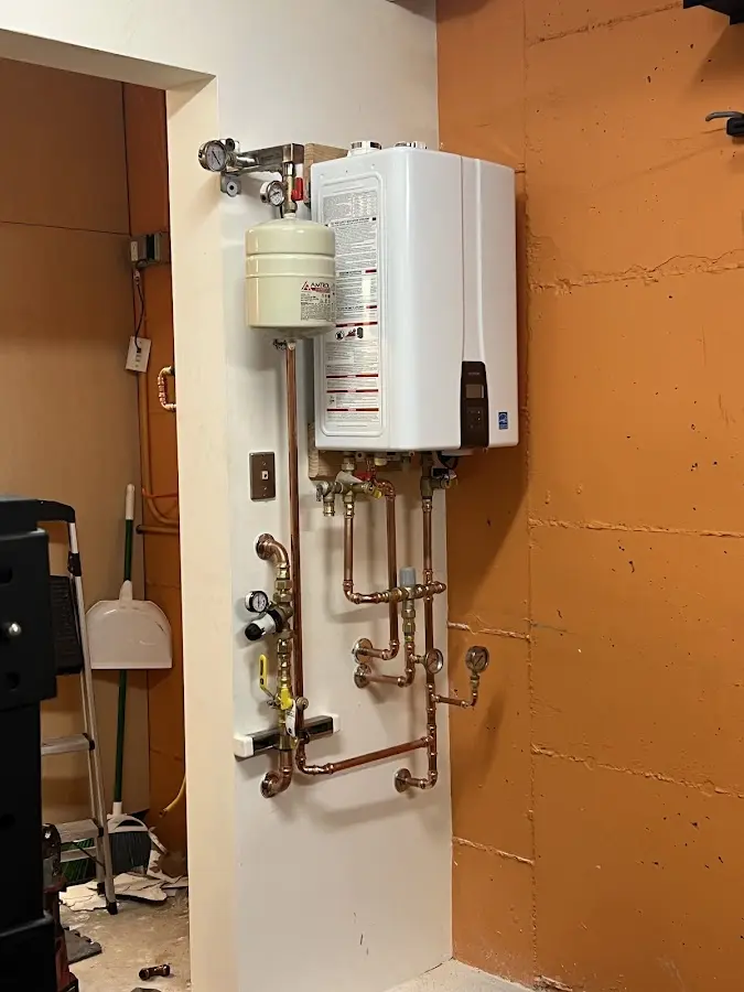 Plumbing technician inspecting water heater connections in Wolfforth